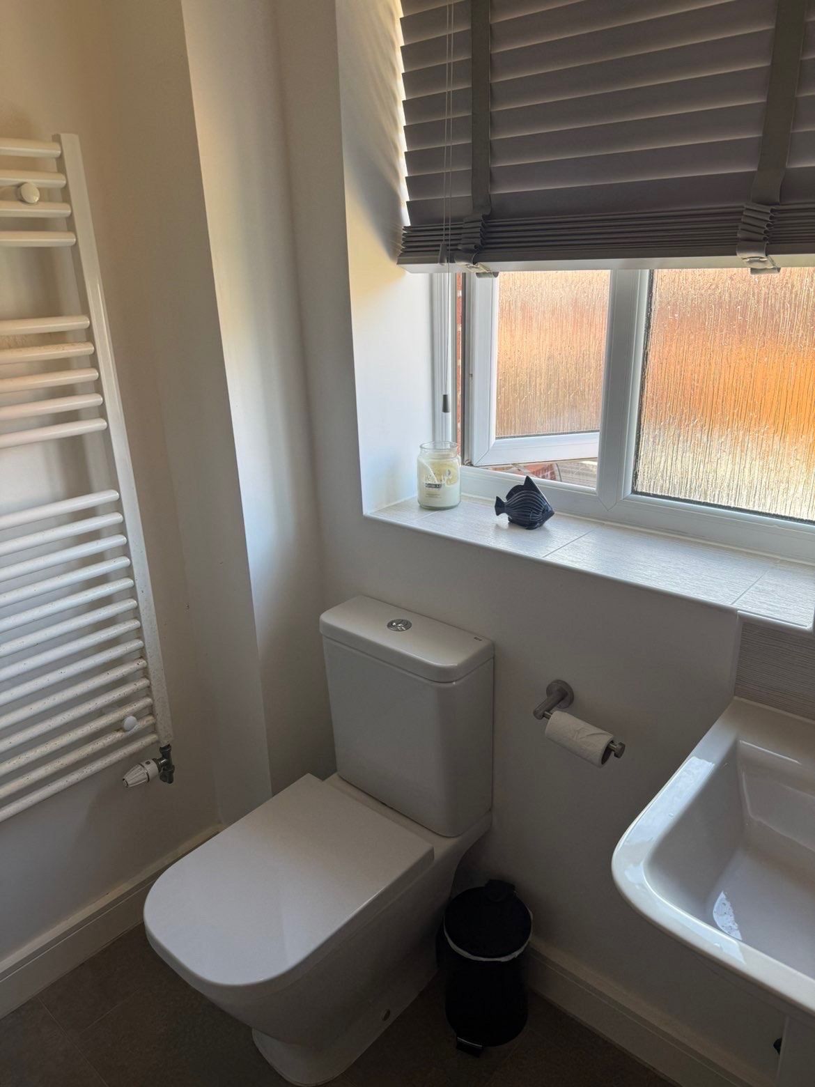 Fresh white bathroom with towel radiator and tidy windowsill