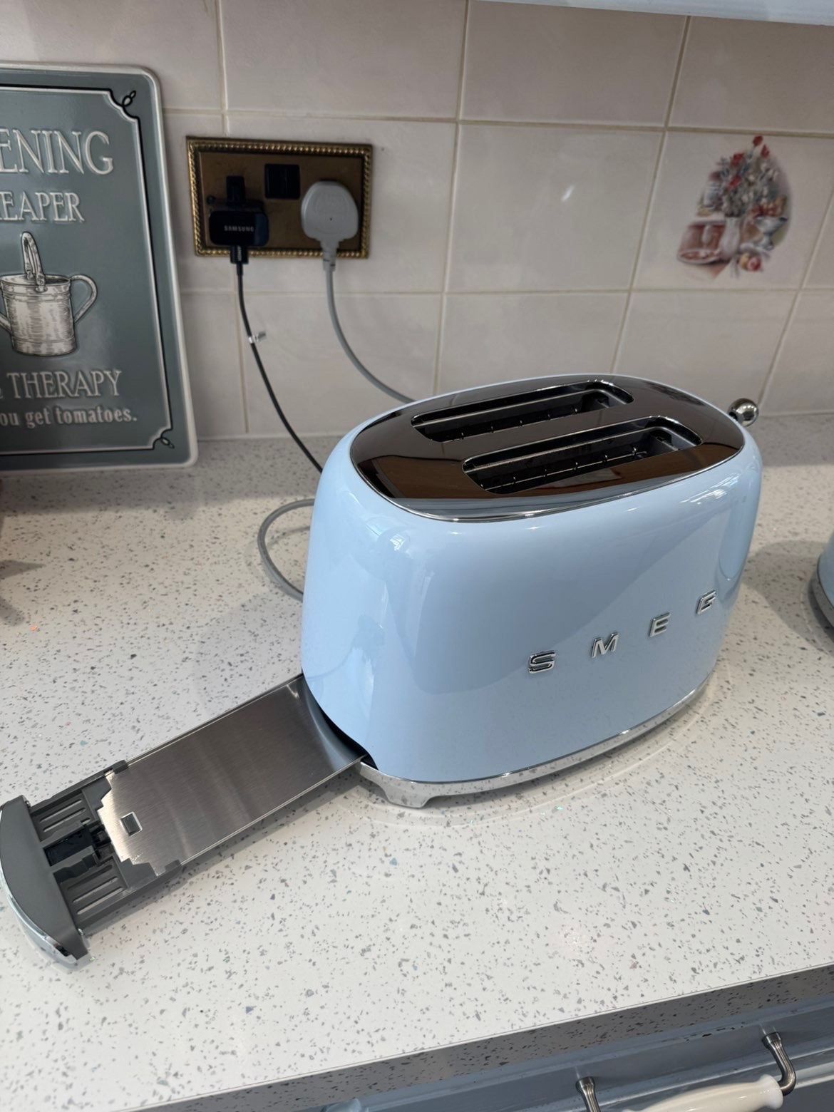 Smeg toaster with its crumb tray pulled out and emptied